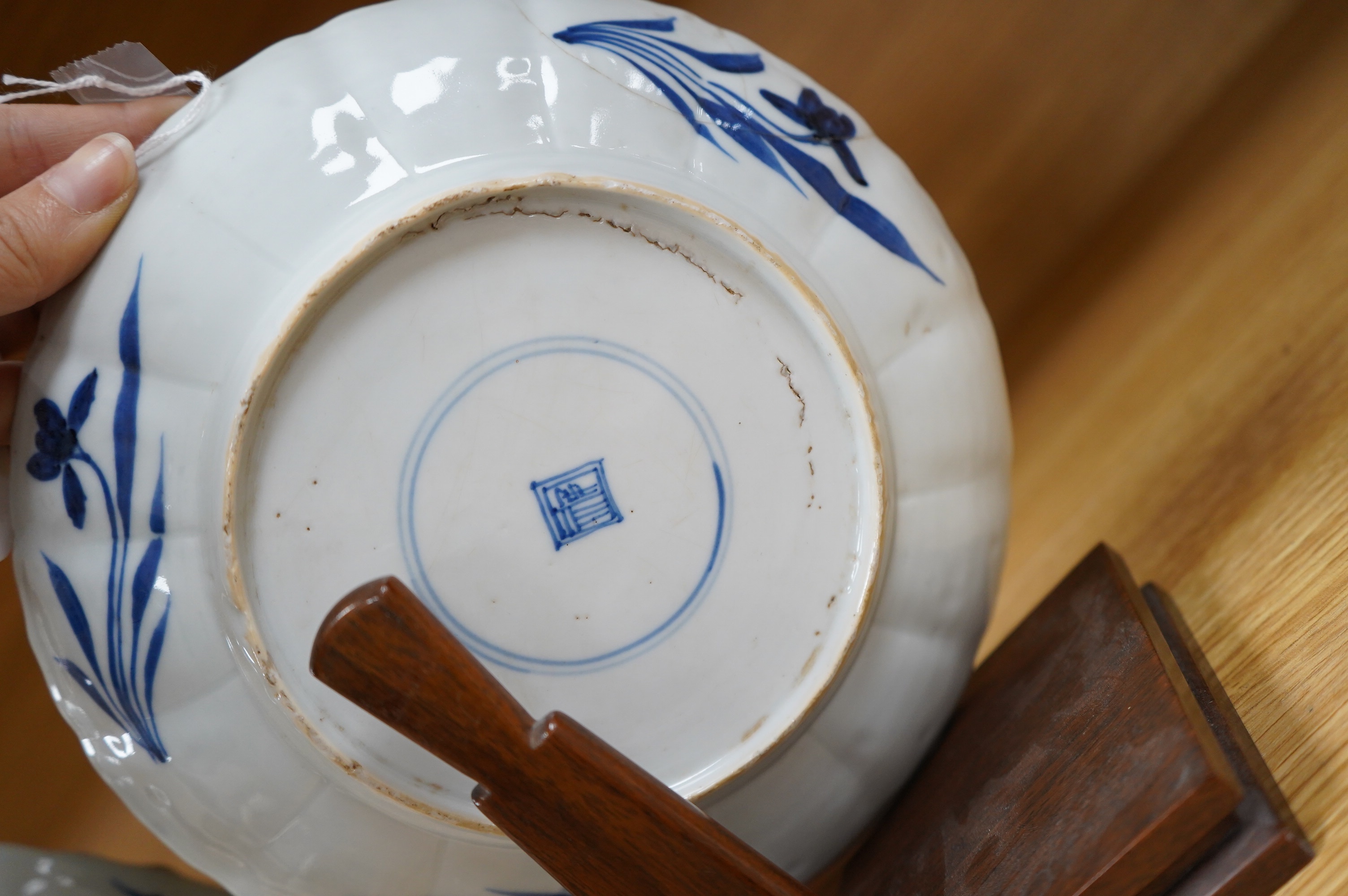 Two Chinese blue and white ‘astor’ plates, Kangxi period, with hardwood stands, largest 22cm diameter. Condition - poor to fair